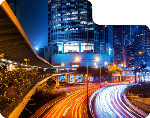 Cityscape at night with illuminated buildings and light trails from moving vehicles, representing dynamic digital marketing strategies by ROC Media.