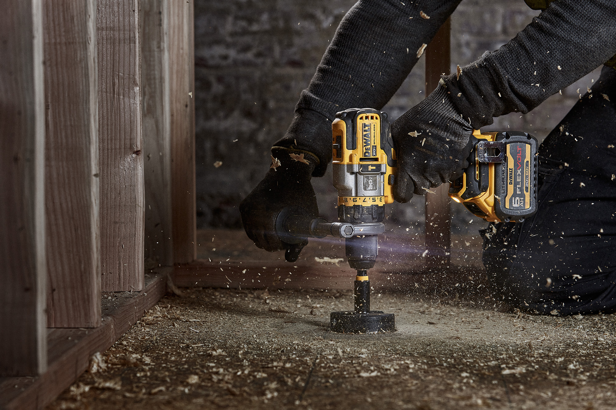 DEWALT® Flexvolt® drill in action, drilling into wood with sawdust flying, showcasing power tools for home improvement and construction.