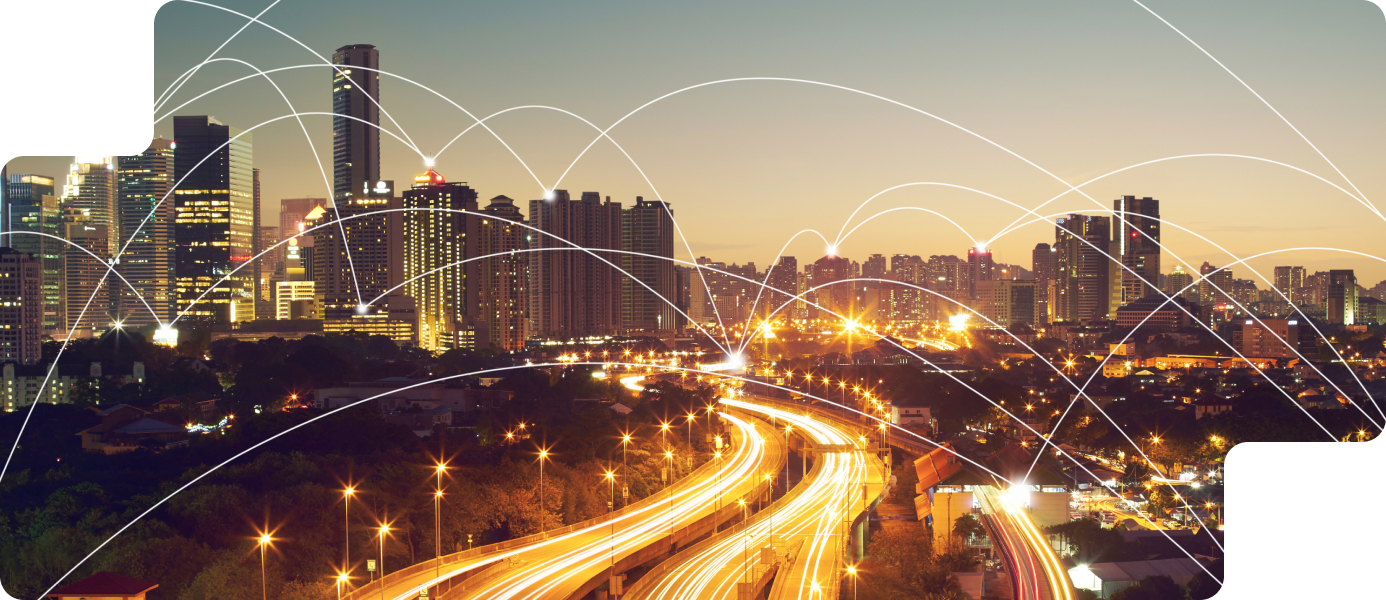 City skyline at dusk with illuminated buildings and traffic, overlaid with dynamic lines representing connectivity, reflecting integrated marketing and cross-channel media strategies.