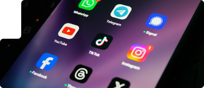 Smartphone screen displaying popular social media app icons including Facebook, Instagram, TikTok, YouTube, WhatsApp, Telegram, Signal, and Twitter, representing digital marketing and organic social media strategies.