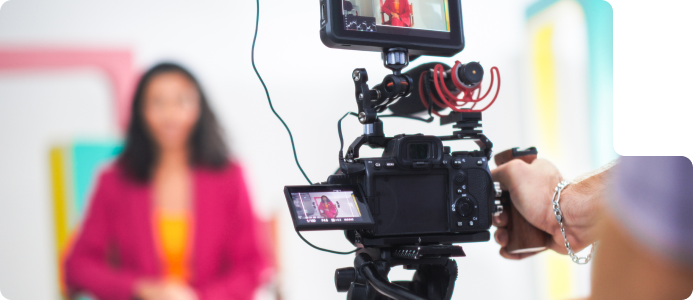 Videography setup with camera focused on a subject in a colorful background, illustrating ROC Media's video production services.