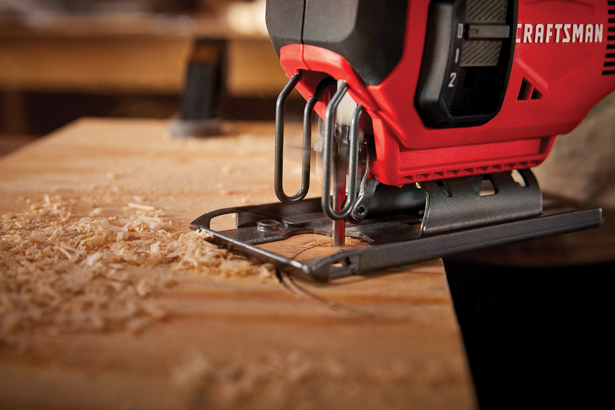 CRAFTSMAN® V20 Battery jigsaw cutting through wood, showcasing precision tools and craftsmanship in a workshop setting.