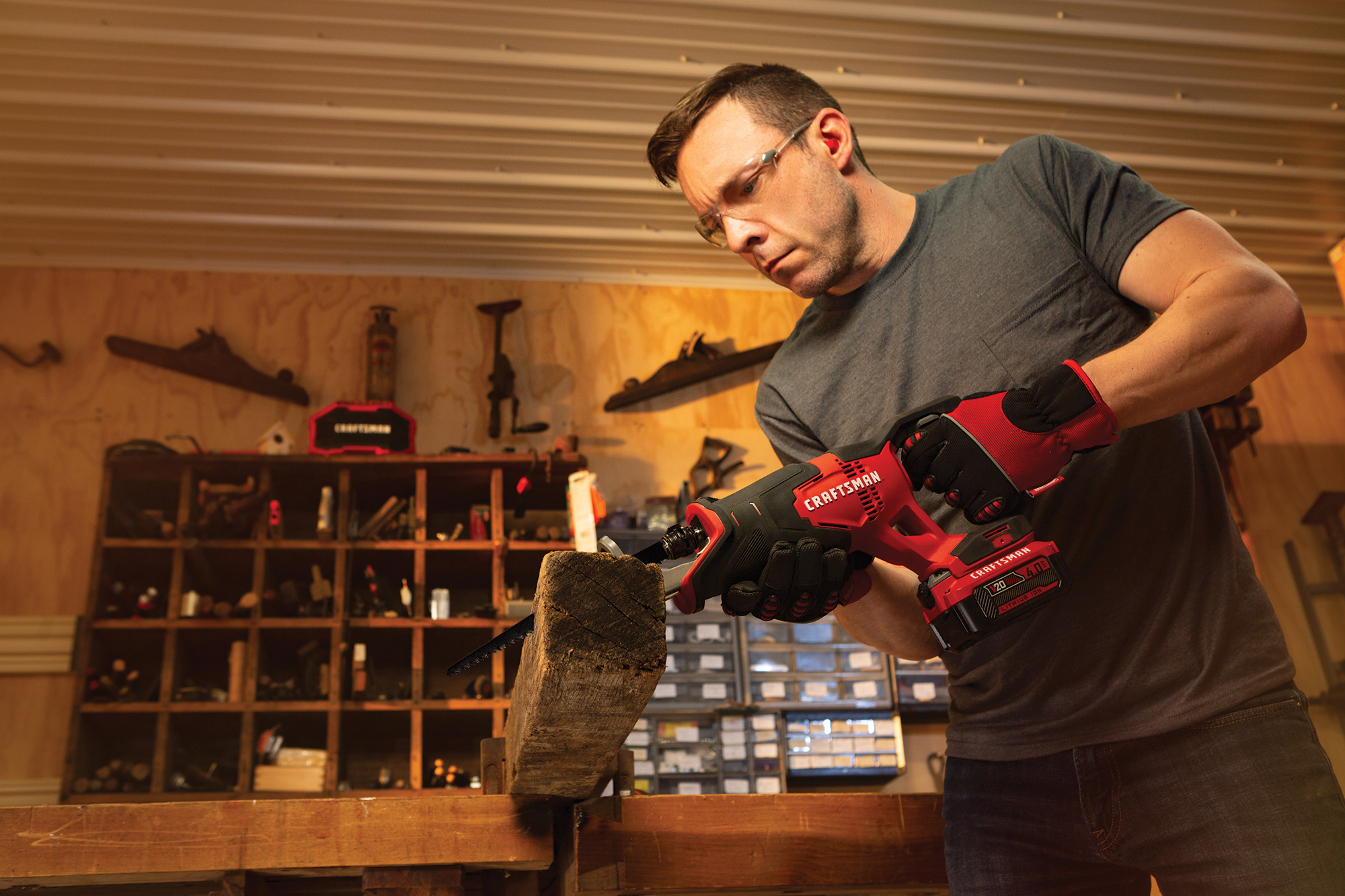 Man using CRAFTSMAN® V20 battery-powered tool to cut wood in a workshop, showcasing durability and versatility for DIY projects.