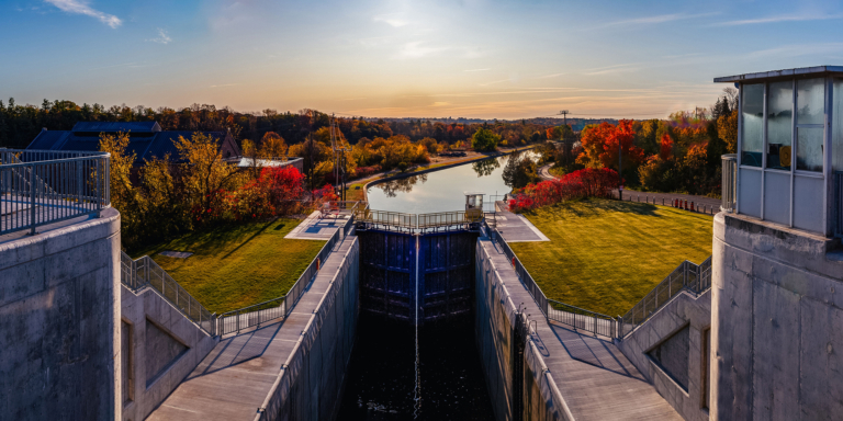 Scenic view of a canal lock with autumn foliage, showcasing ROC Media's commitment to local landscapes and community engagement in digital marketing projects.