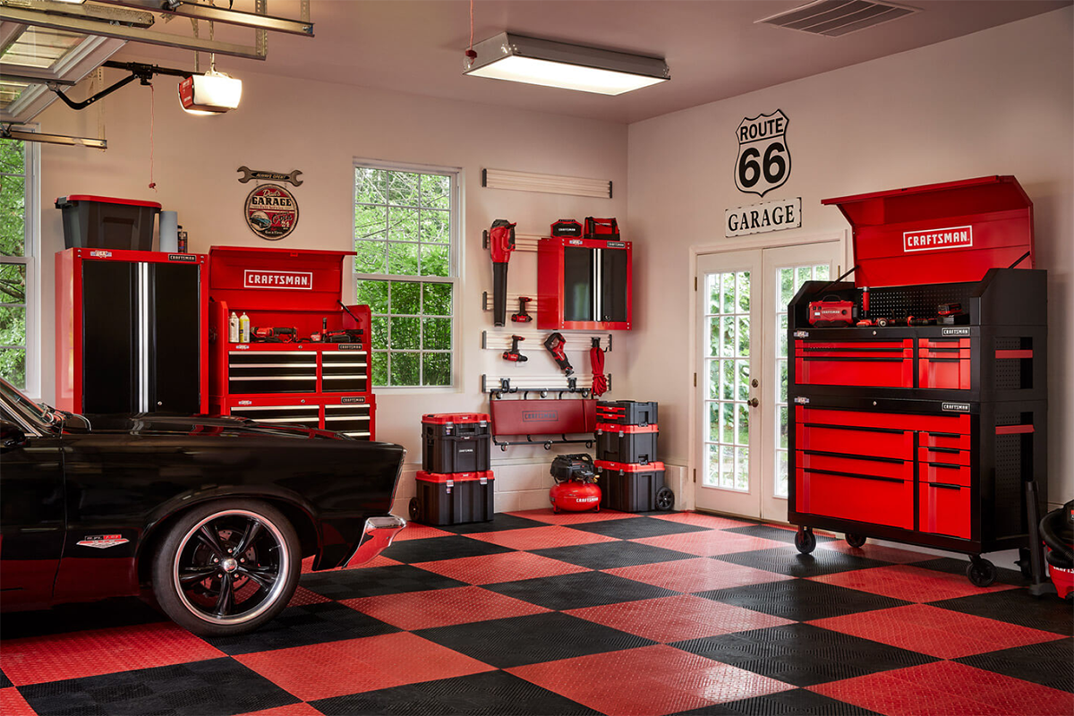 Craftsman Dream Garage featuring red tool storage cabinets, a black classic car, and a checkered floor, illustrating an ideal workspace for builders and auto enthusiasts.