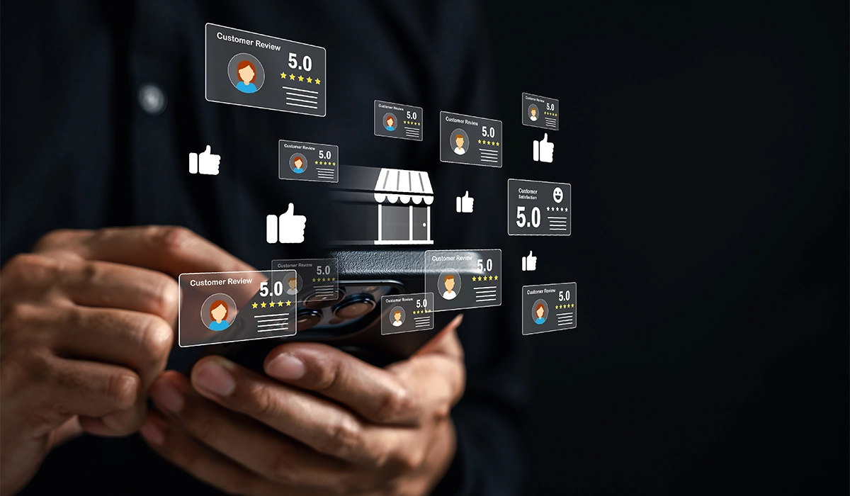 Hands holding a smartphone displaying multiple positive online reviews with 5-star ratings, representing the impact of customer feedback on brand perception in digital marketing.
