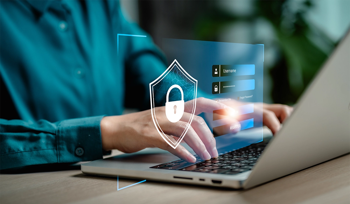 Person typing on a laptop with a digital security shield overlay, emphasizing privacy-first marketing and customer data protection.