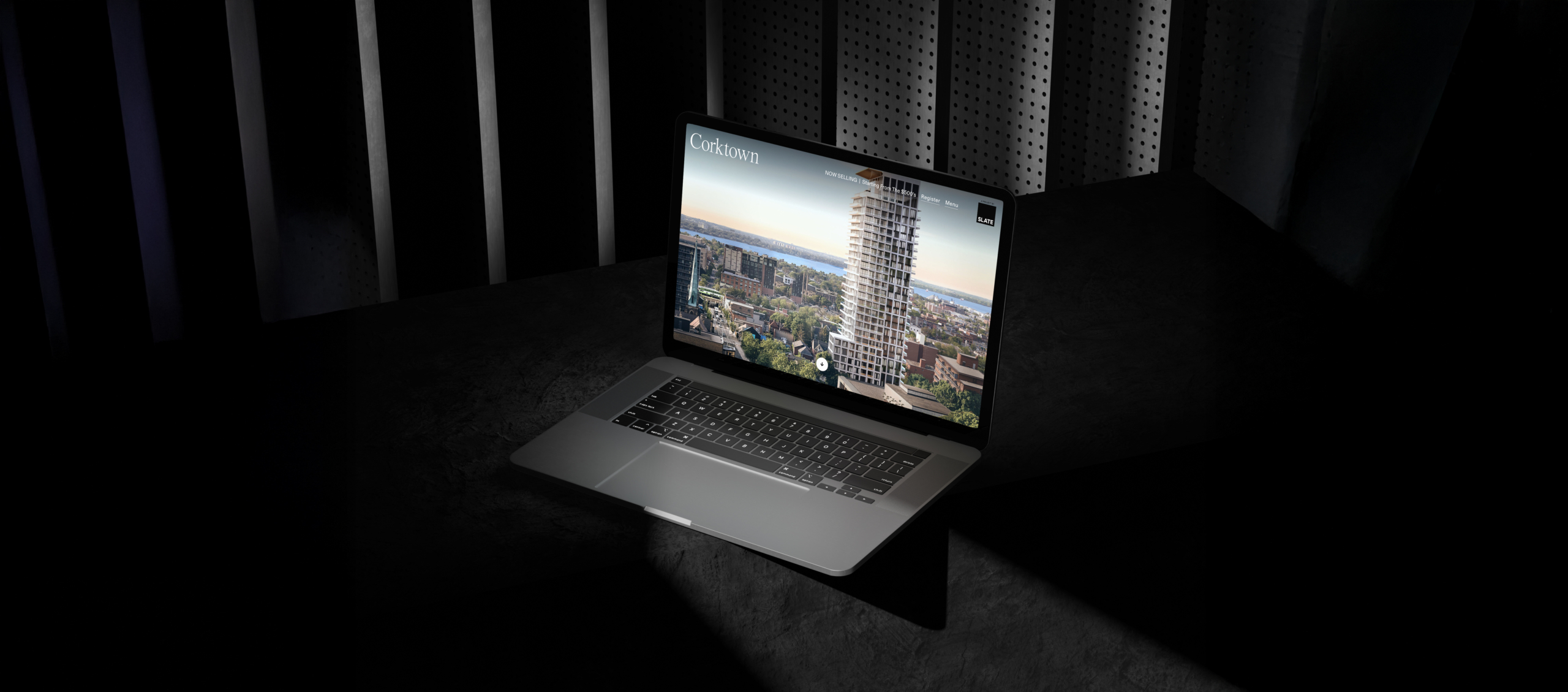 Laptop displaying the Corktown website featuring a modern residential building and urban landscape, set against a dark background, highlighting the project's design-forward approach.