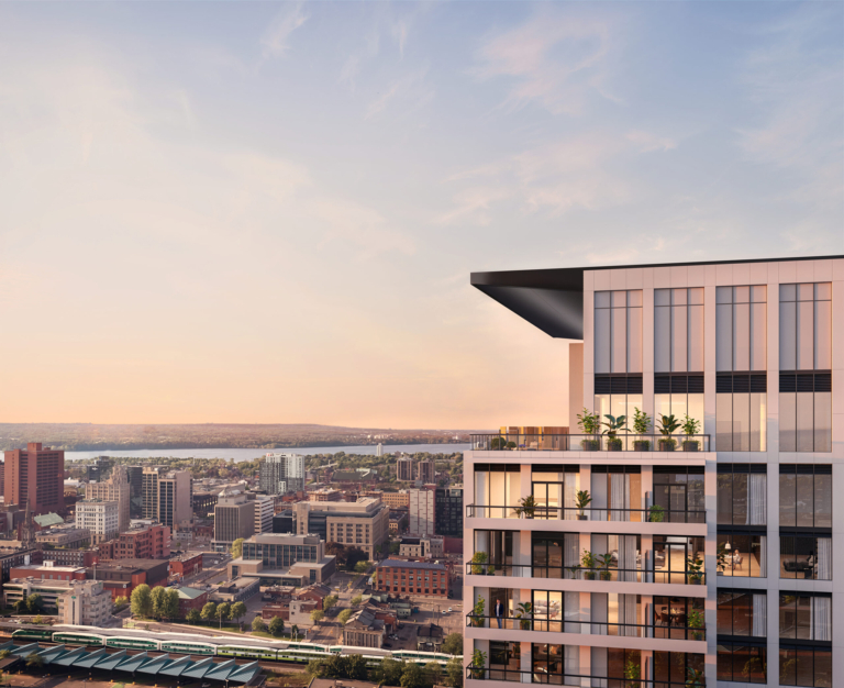 Modern residential building in Corktown, showcasing sleek architecture and urban landscape, with greenery on balconies and a sunset backdrop over Hamilton's skyline.