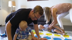 Family playing with children on a colorful mat in a cozy living room, showcasing a nurturing environment for family bonding and early childhood development.